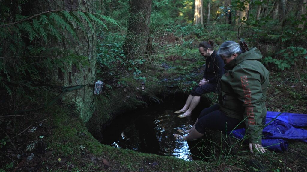 Still from Nature Girl shows Candace Campo and Trent Maynard in a forest bathing pool for black bears 