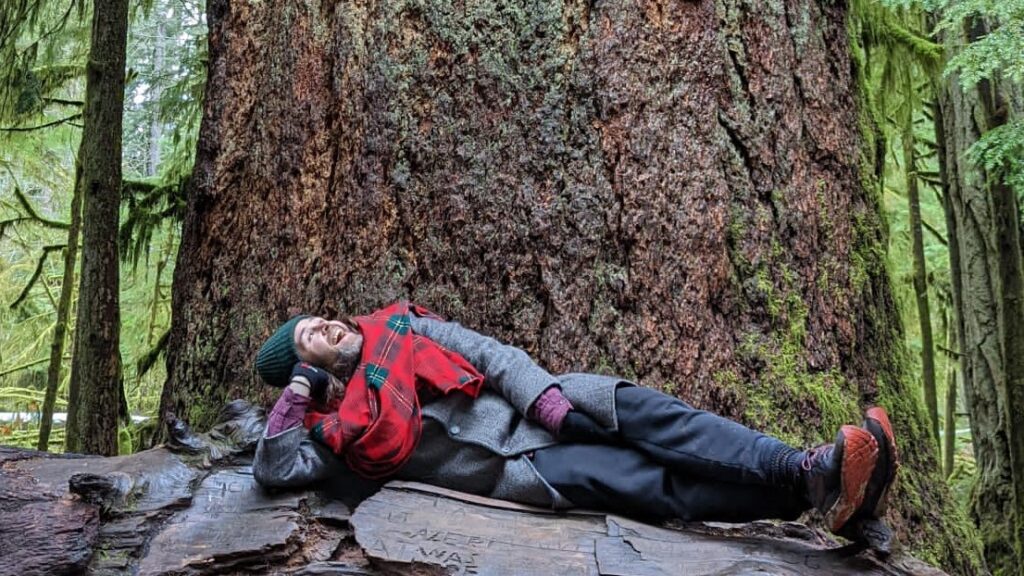 Trent Maynard reclines by old growth fir